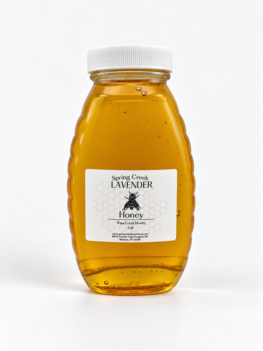 A clear plastic jar of Spring Creek Lavender Honey with a white ribbed cap and a white label featuring a black bee logo, set against a plain white background.