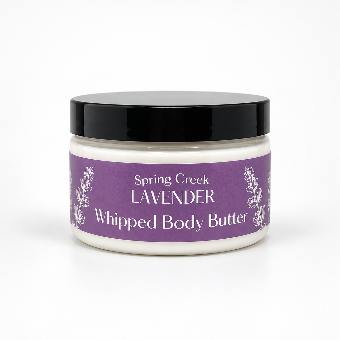 A jar of Spring Creek Lavender Whipped Body Butter with a purple label and black lid, set against a plain white background.